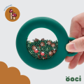 ÖOCI Pop Loop Las – zielona sensoryczna grzechotka z jeżykami i muchomorkami